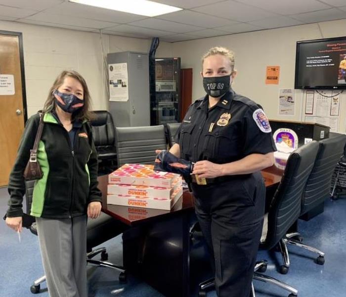 SERVPRO staffer presents donuts to police captain